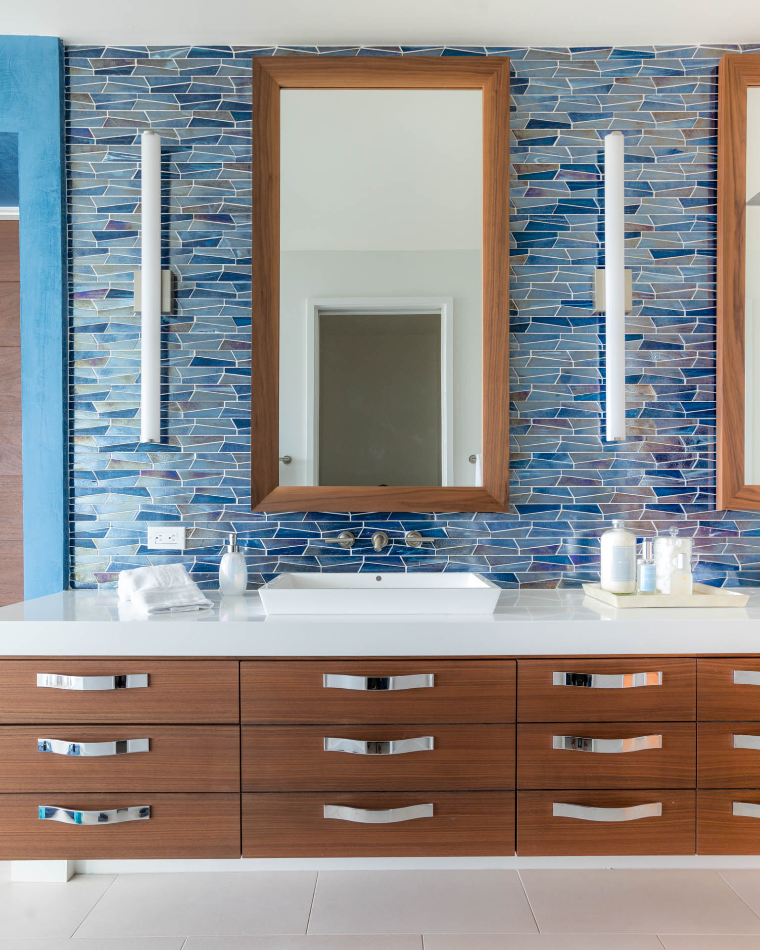 Studio M's award-winning interior design transforms narrow Fernandina Beach lot into luxurious three-story coastal home with modern aesthetics, custom blue accents, and innovative space utilization